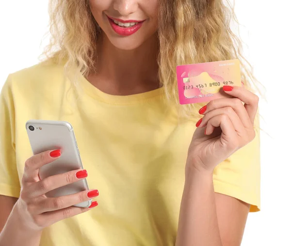 Mladá žena s kreditní kartou a mobilním telefonem na bílém pozadí — Stock fotografie