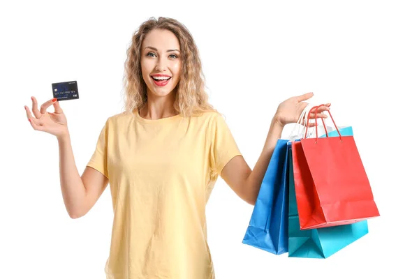 Νεαρή γυναίκα με πιστωτική κάρτα και τσάντες για ψώνια σε λευκό φόντο — Φωτογραφία Αρχείου