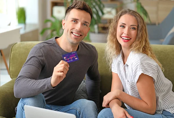 Mladý pár s kreditní kartou doma — Stock fotografie