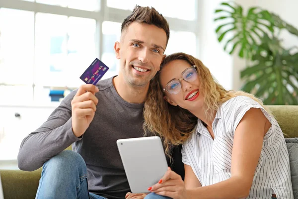 Mladý pár s kreditní kartou a tabletu doma — Stock fotografie