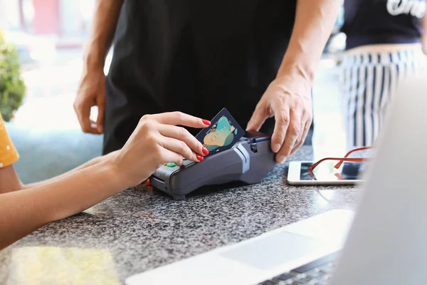 Young woman paying by credit card in cafe — Stock Photo, Image