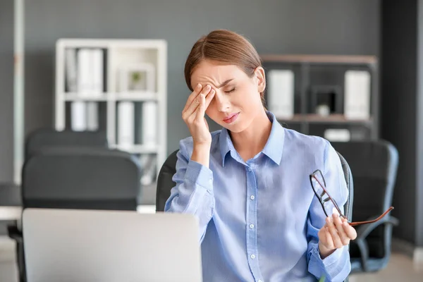 Giovane donna che soffre di mal di testa in ufficio — Foto Stock