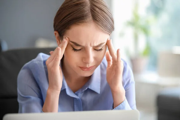 Молодая женщина страдает от головной боли в офисе — стоковое фото