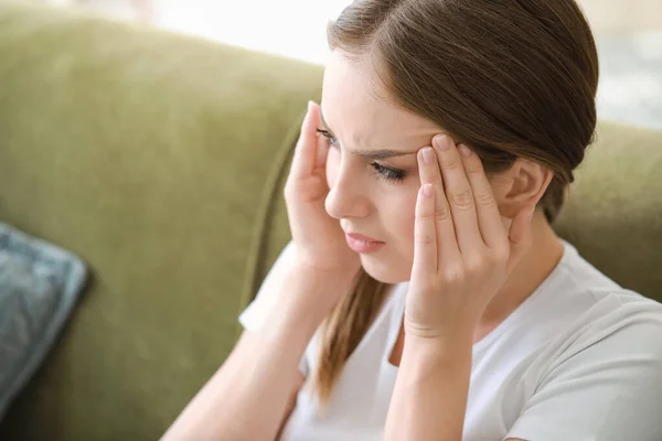 Mujer joven que sufre de dolor de cabeza en casa — Foto de Stock