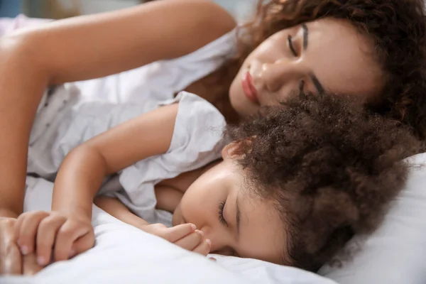 Niña afroamericana con madre durmiendo en la cama — Foto de Stock