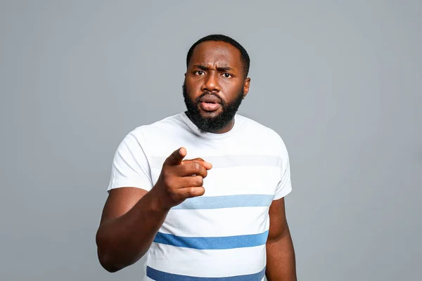 Troubled African-American man pointing at viewer on grey background — Stock Photo, Image