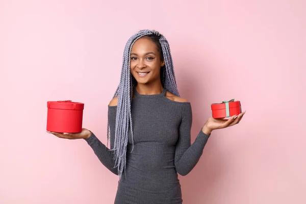 Belle femme afro-américaine avec des cadeaux sur fond de couleur — Photo