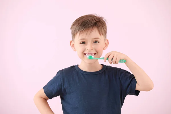 Porträt eines kleinen Jungen beim Zähneputzen auf farbigem Hintergrund — Stockfoto