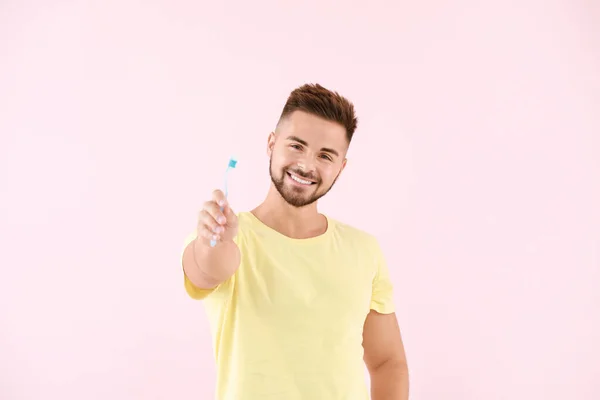 Retrato de hombre con cepillo de dientes sobre fondo de color —  Fotos de Stock