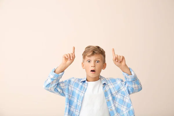 Surprised little boy pointing at something on white background — Stock Photo, Image