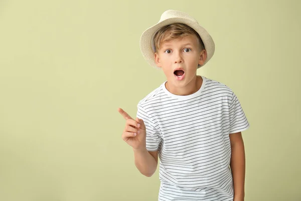 Surprised little boy pointing at something on color background — Stock Photo, Image