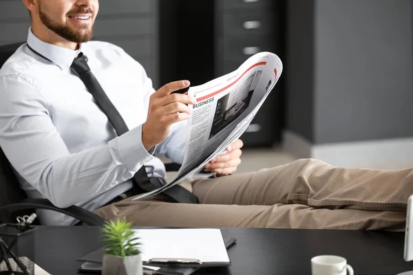 Красивий бізнесмен читає газету в офісі — стокове фото