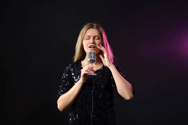Linda jovem cantora com microfone no palco — Fotografia de Stock