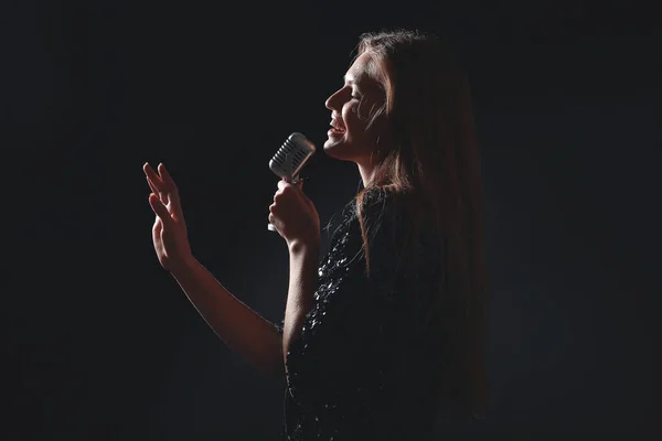 Hermosa joven cantante femenina con micrófono en el escenario — Foto de Stock