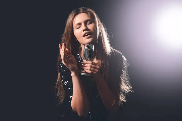 Linda jovem cantora com microfone no palco — Fotografia de Stock