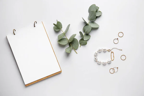 Stylish female jewelry with notebook on white background — Stock Photo, Image