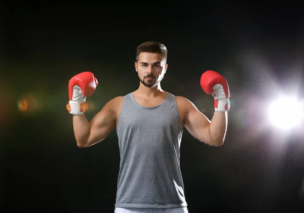Sporty male boxer on dark background