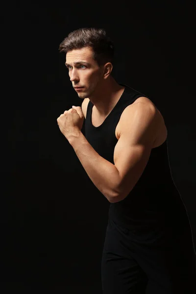 Sporty young man running against dark background — Stock Photo, Image