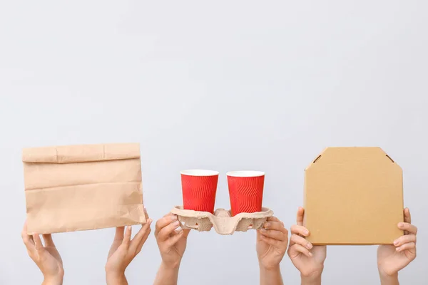 Many hands with food containers and cups on light background — Stock Photo, Image