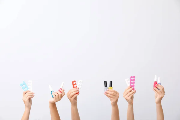 Muchas manos con suministros para la pedicura sobre fondo blanco — Foto de Stock