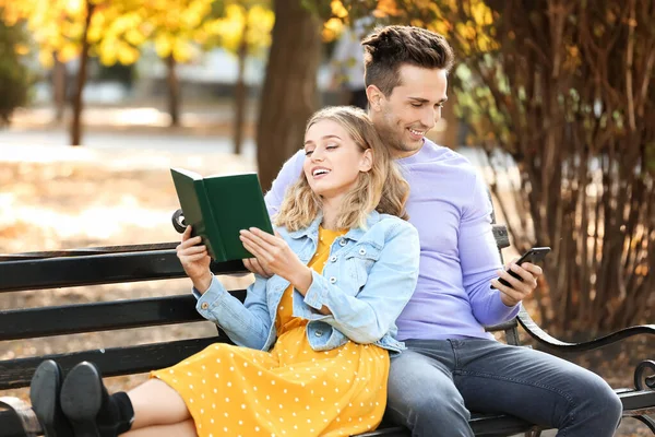 Linda pareja joven con libro sobre cita romántica en el parque — Foto de Stock