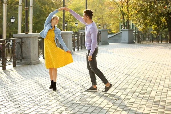 Glückliches junges Paar tanzt bei romantischem Date im Park — Stockfoto