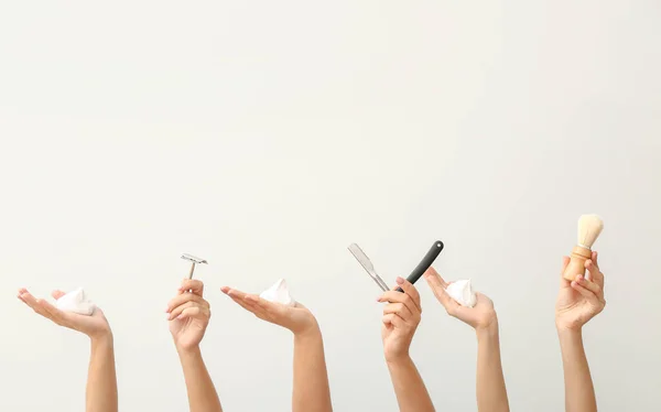 Mãos com diferentes ferramentas para barbear no fundo branco — Fotografia de Stock
