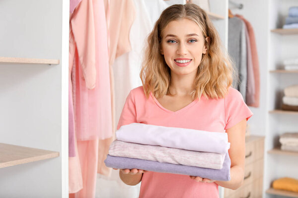 Woman with stack of clean clothes at home