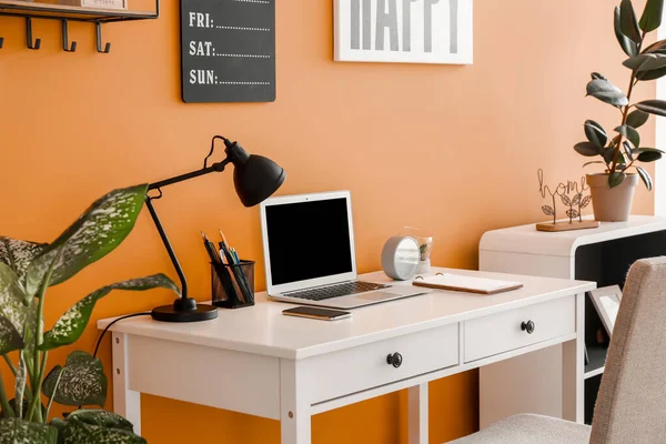 Stylish workplace with laptop near color wall — Stock Photo, Image