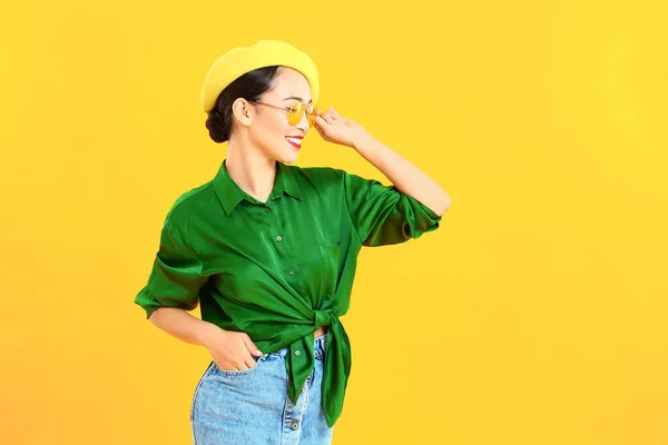 Fashionable Asian woman on color background — Stock Photo, Image