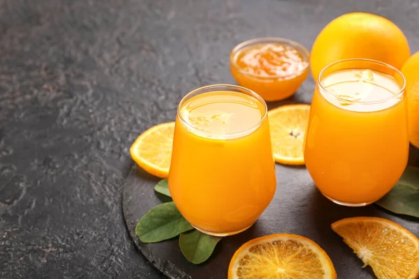 Стаканы свежего апельсинового сока на темном фоне — стоковое фото