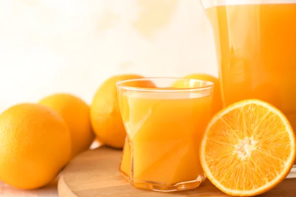 Стекло и кувшин свежего апельсинового сока на борту — стоковое фото