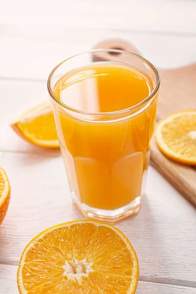 Ποτήρι φρέσκου χυμού πορτοκαλιού σε λευκό τραπέζι — Φωτογραφία Αρχείου