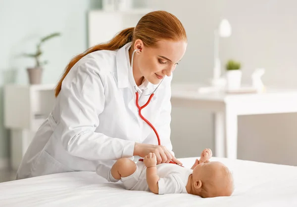 Kinderarts onderzoekt schattige baby in kliniek — Stockfoto