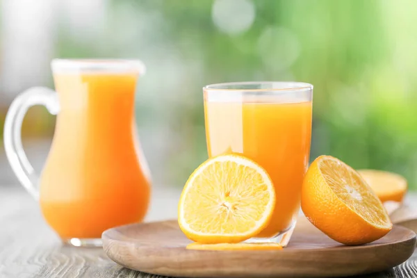 Glass of fresh orange juice on table outdoors — Stock Photo, Image