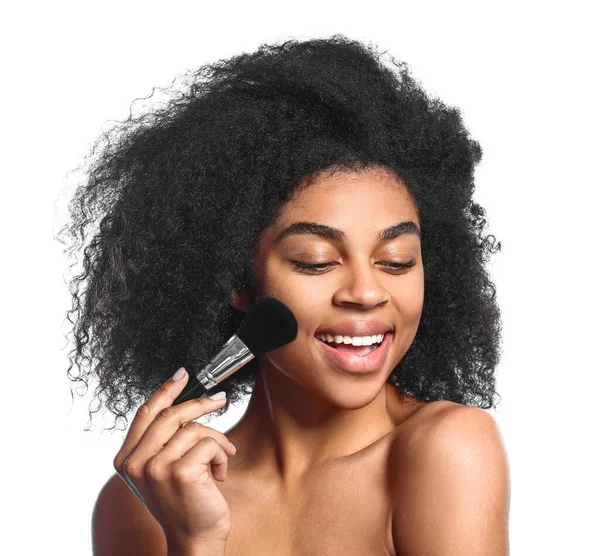 Portrét krásné afroamerické ženy s make-up štětcem na bílém pozadí — Stock fotografie