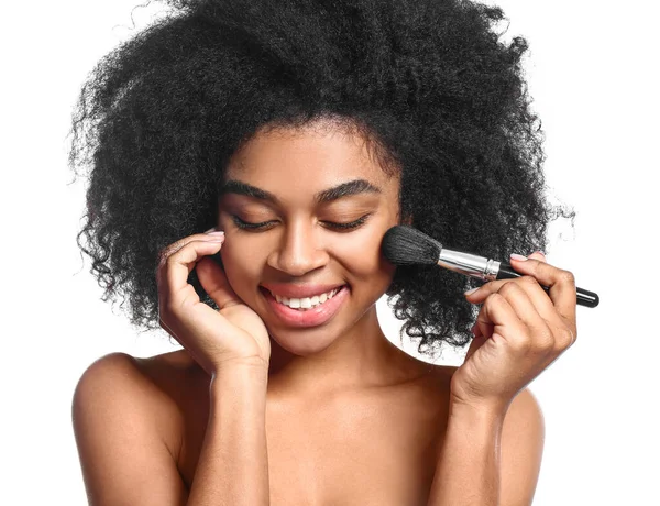 Portret van mooie Afro-Amerikaanse vrouw met make-up borstel op witte achtergrond — Stockfoto