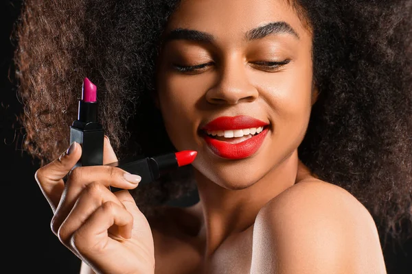 Portrait of beautiful African-American woman with bright lipsticks on dark background, closeup — Stock Photo, Image