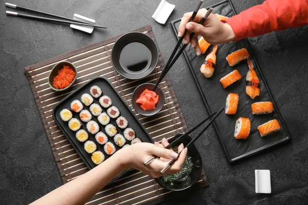 Ženy jedí chutné sushi u stolu — Stock fotografie