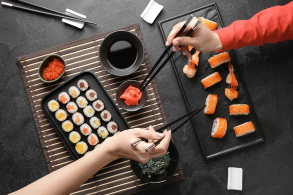 Frauen essen schmackhaftes Sushi am Tisch — Stockfoto