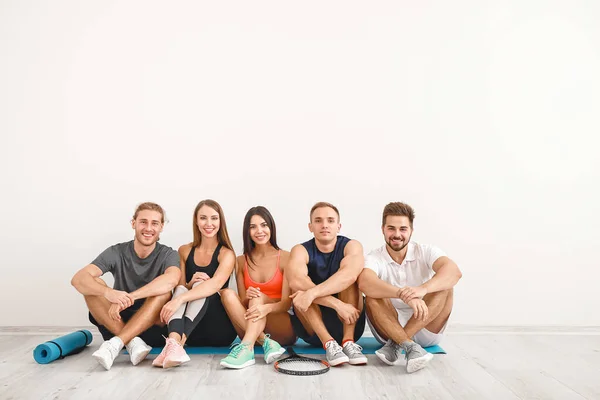 Groep van sportieve vrienden bij witte muur — Stockfoto