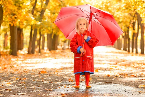 Cute little girl with umbrella in autumn park — Stock Photo, Image