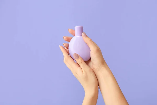 Female hands with bottle of perfume on color background — Stock Photo, Image