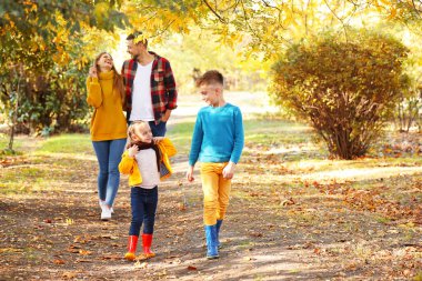 mutlu bir aile sonbahar parkta yürüyüş