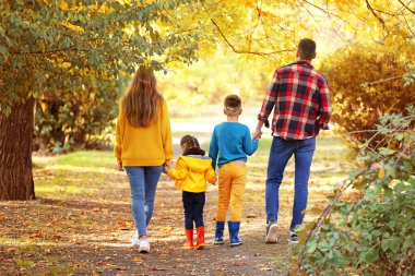 mutlu bir aile sonbahar parkta yürüyüş