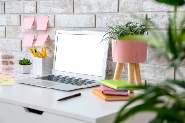 Tuğla duvarın yanında dizüstü bilgisayarı olan modern stil bir iş yeri