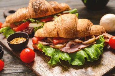 Lezzetli kruvasan sandviç ahşap tahta, closeup üzerinde