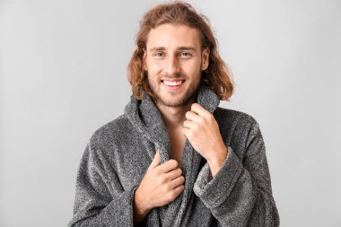 Gri arka planda bornozlu yakışıklı bir adamın portresi.