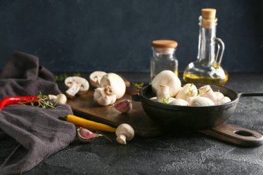 Koyu arkaplanda taze mantarlı, baharatlı ve yağlı tava.