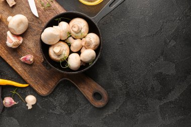 Taze mantarlı tava ve koyu arkaplanda baharatlar.